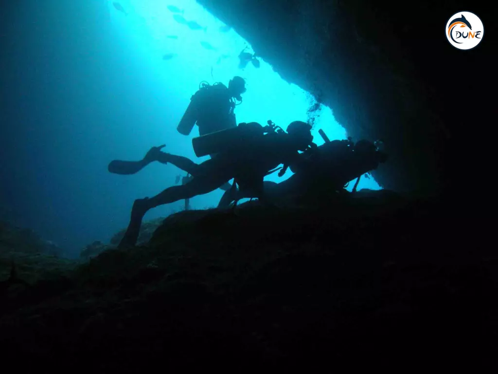 3 divers under cave